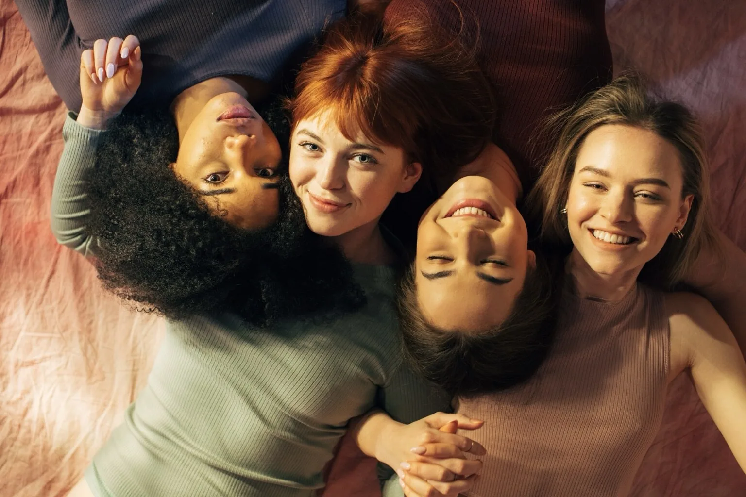 A diverse group of women resting together and smiling