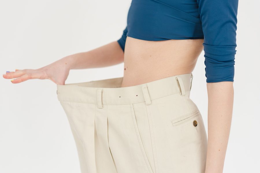 A person holding clothing after a change in fit