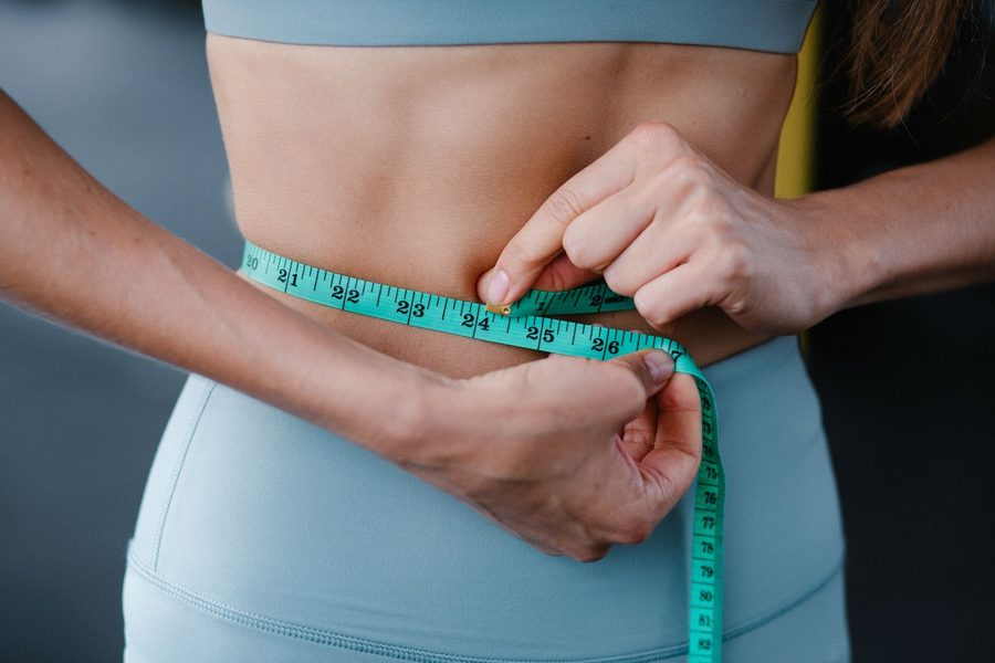 A person measuring their waist