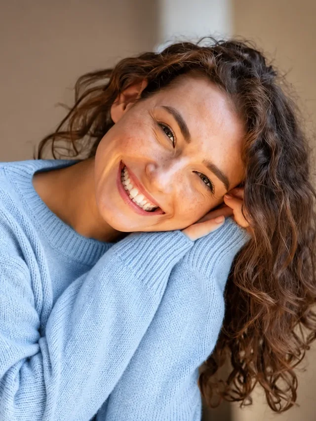 Smiling woman relaxing at home in a blue sweater